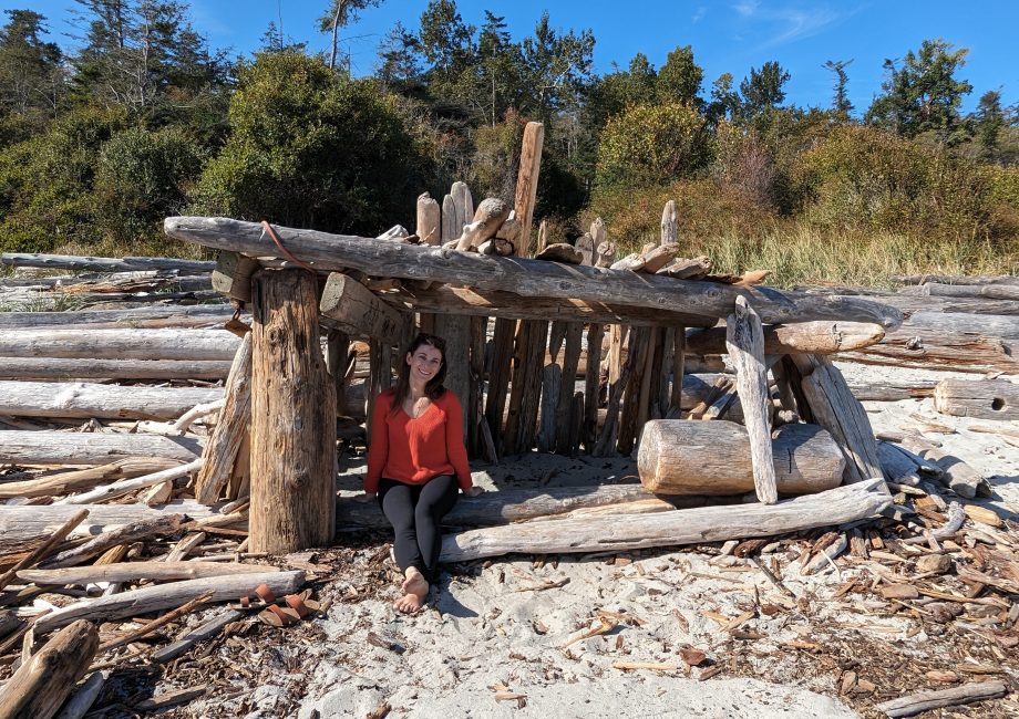 Emily Gunner, Founder Manor and Bloom sitting in a man made shelter on a beach
